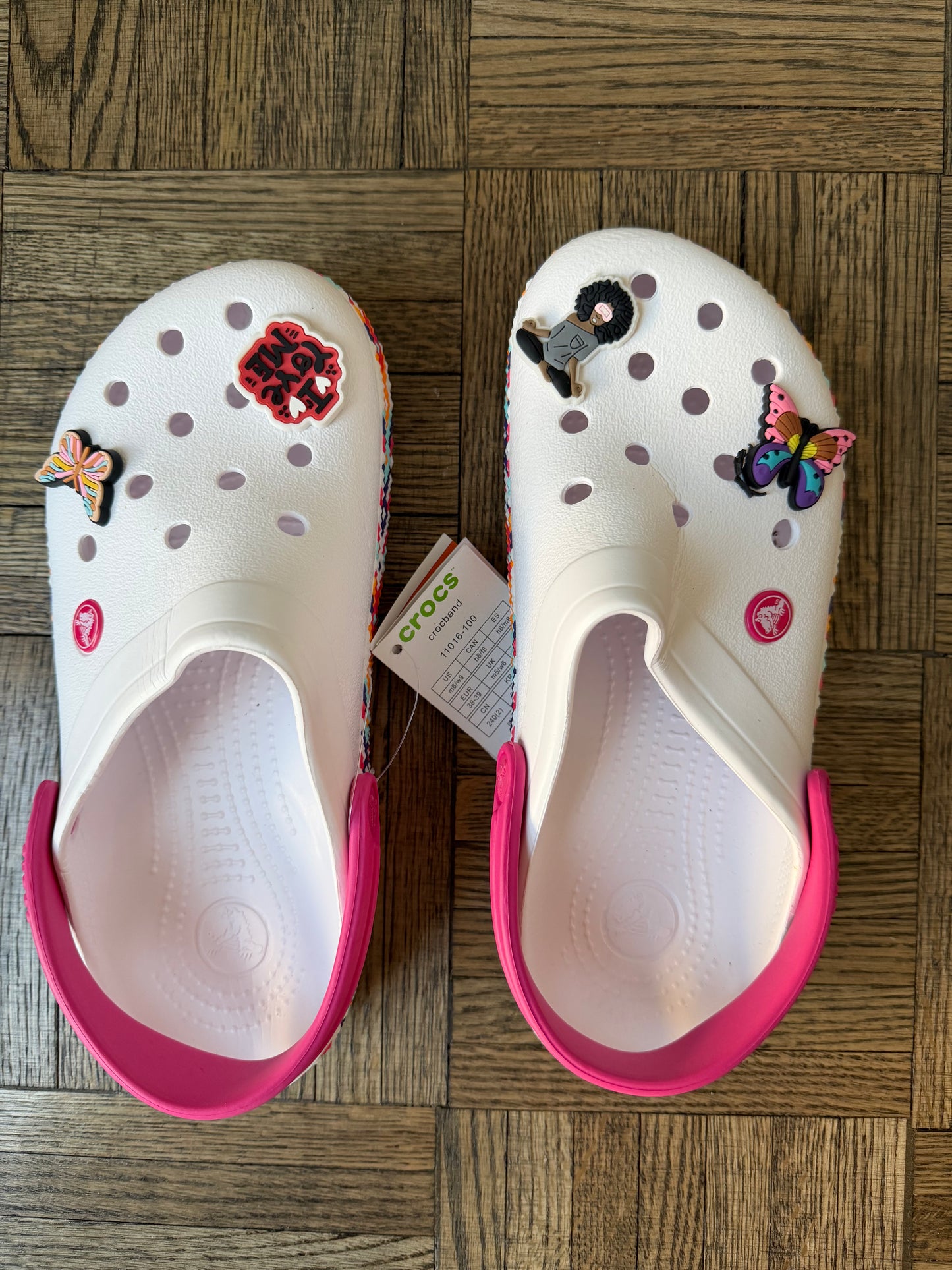 WHITE CROCS WITH PINK TRIM AND BUTTERFLY CHARMS